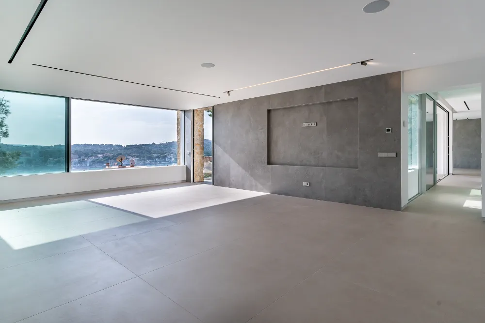 Open-plan living room with concrete feature wall and sea view