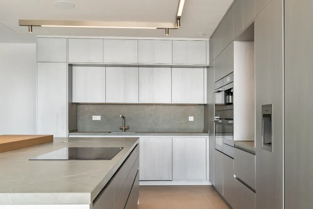 Contemporary fitted kitchen with pale cabinetry, island and integrated appliances