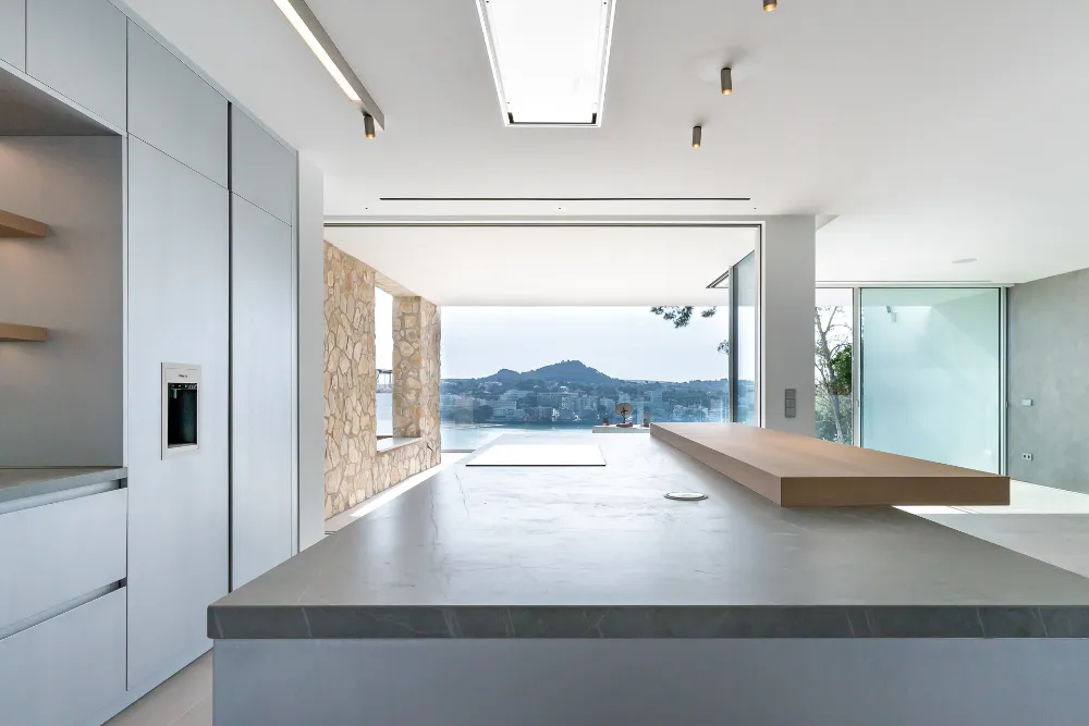 Kitchen island looking towards the sea through open-plan living space