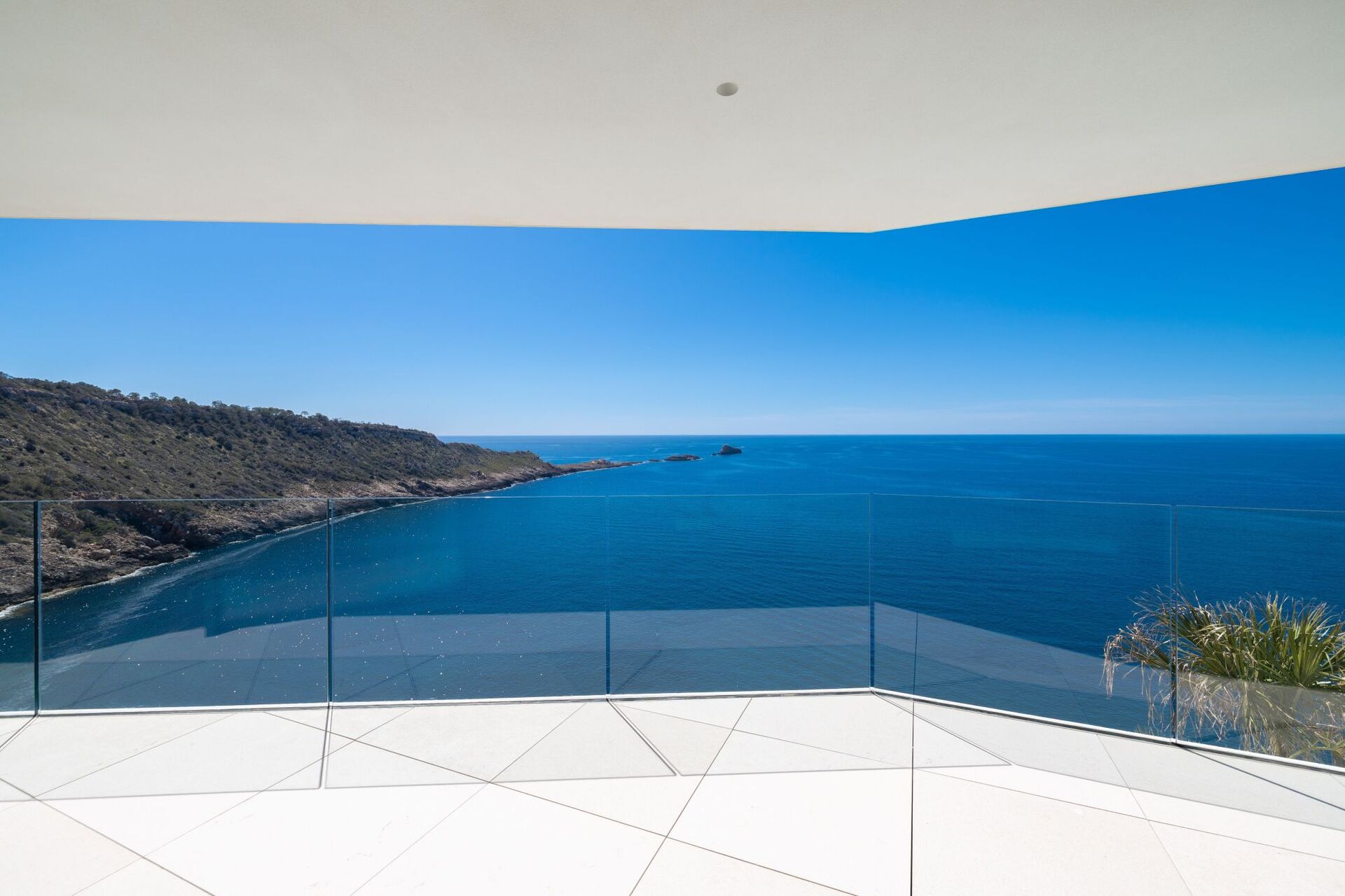 Wide terrace with glass balustrade and uninterrupted Mediterranean sea view