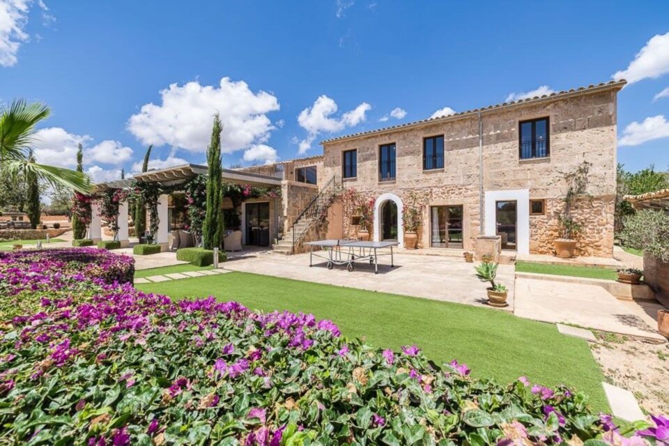 Traditional Mallorcan stone house with landscaped garden and flowering foreground